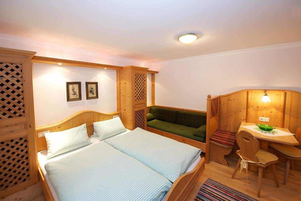 Gemütliches Doppelzimmer im Forsthaus Pernthaner mit Holzmöbeln und Sitzecke.